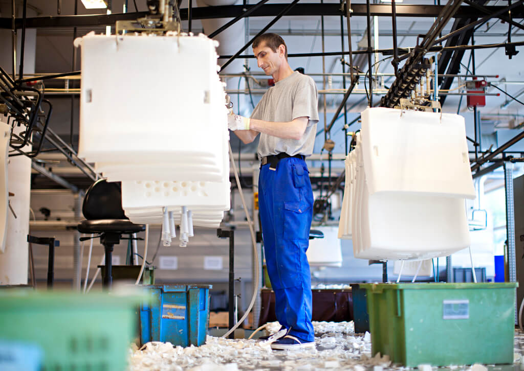 ueber-stressless-produktion Bild aus der Stressless Fabrik in Norwegen. Ein Arbeiter fertigt die Sitzkissen der Stressless Sessel an